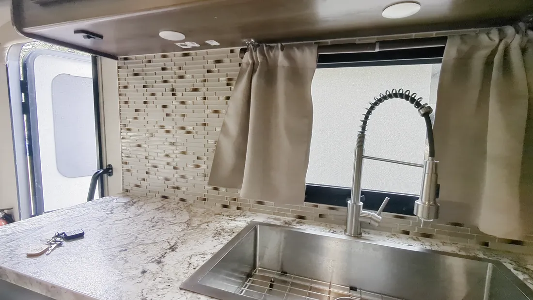 The kitchen sink and counter under the window